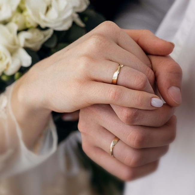 Close-up of couple wearing elegant wedding rings symbolizing love and commitment